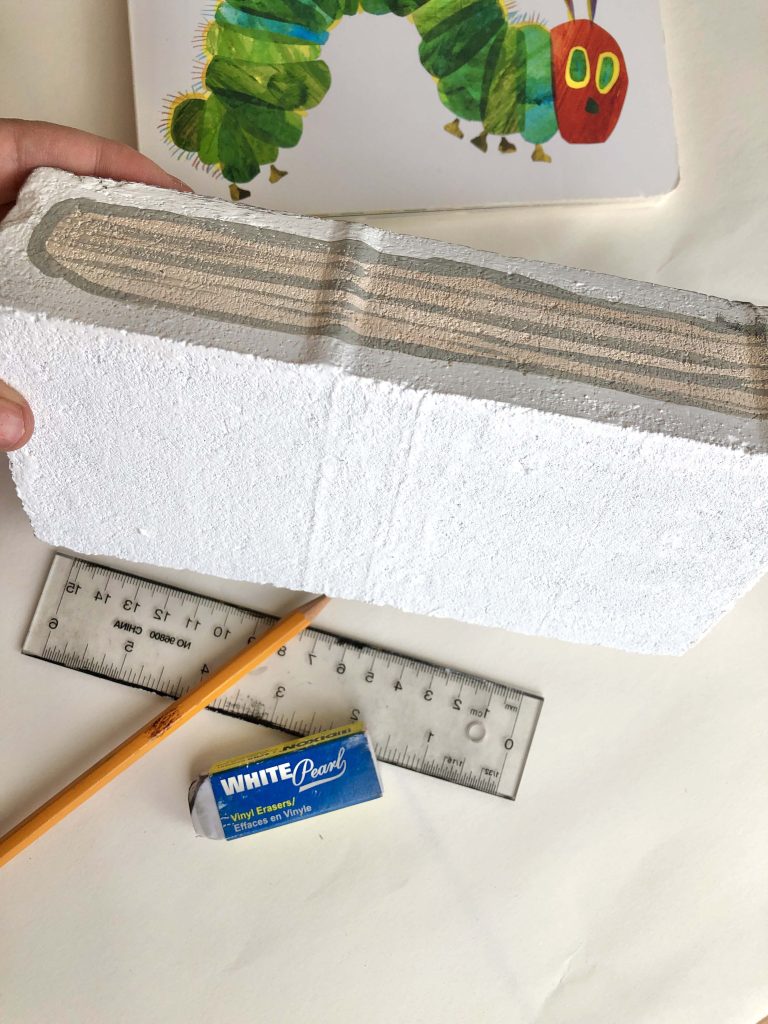 A brick with painted faux pages. How To Paint Bricks to Look Like Books