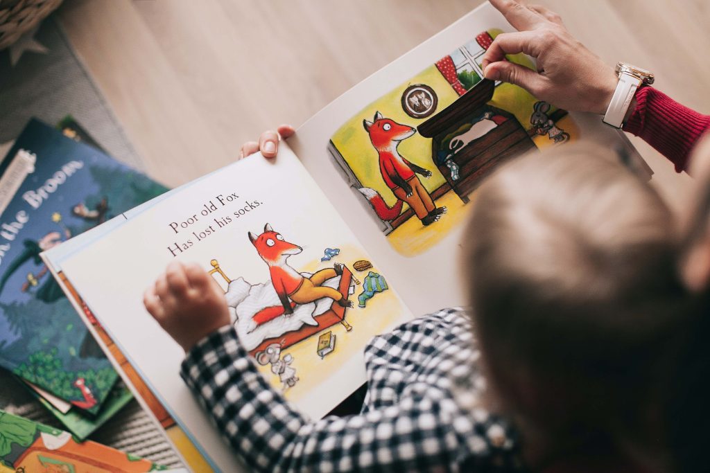 A small child looks at the pages of a book. Six Tips for Creating a Picture Book